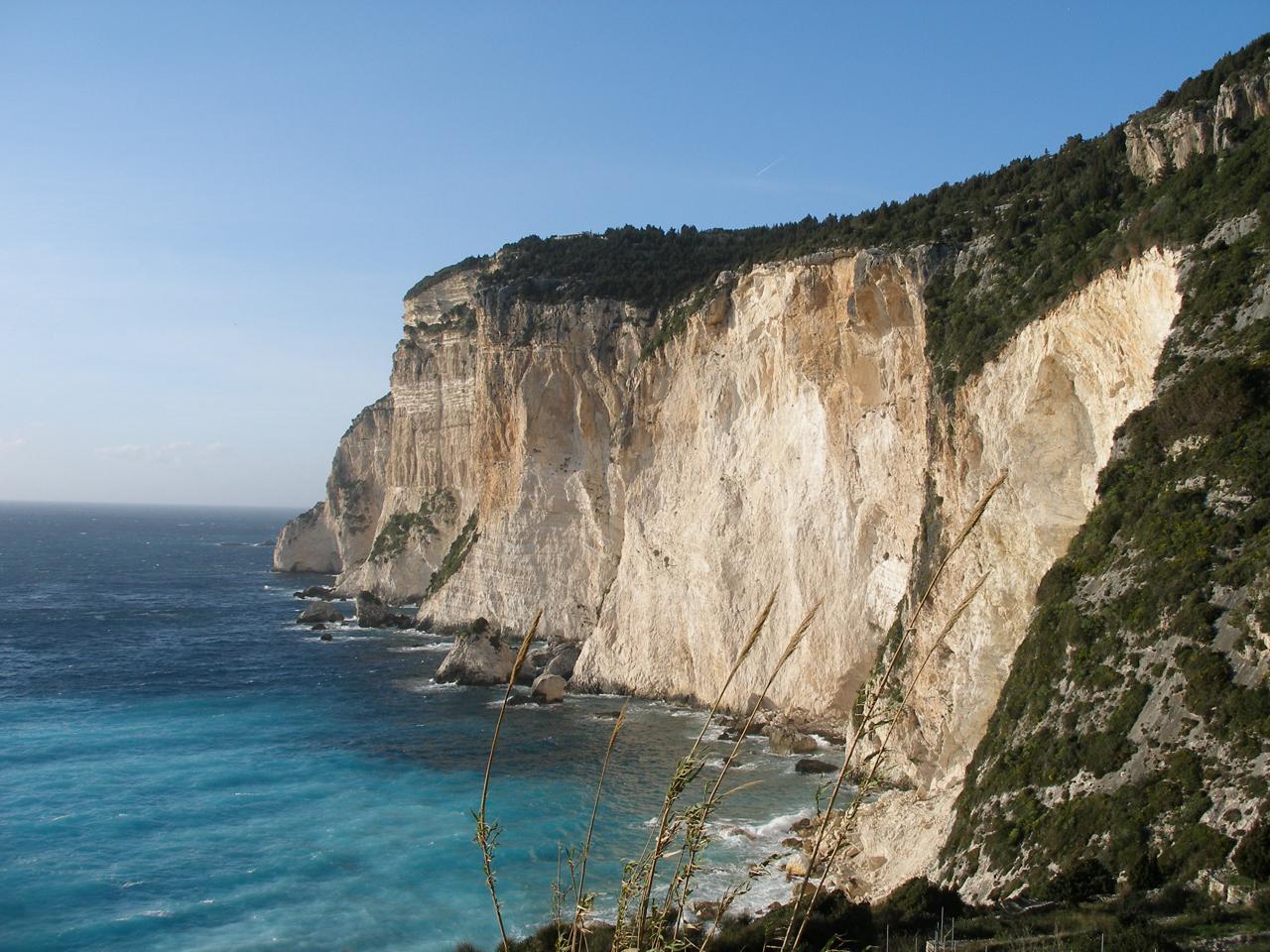 Discover Erimitis Beach in Paxos, a wild and breathtaking destination with white cliffs, turquoise waters, and one of the most magical sunsets in the Ionian. Plan your visit with GoPaxos.